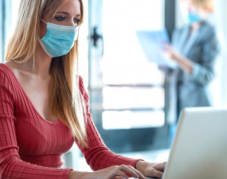 Mujer llevando mascarilla en la oficina 