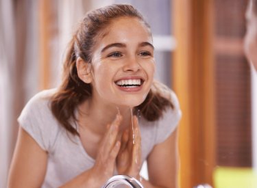 Tu piel - adolescente sonriendo en el espejo 