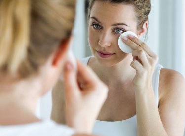 Mujer con piel madura limpiando su rostro